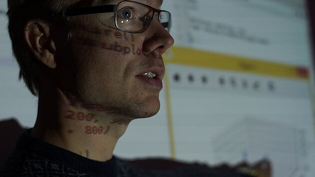 head of a man i profile pointing towards a screen