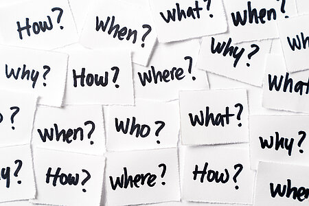 lots of white stickers with questions on them (who, what, how?)