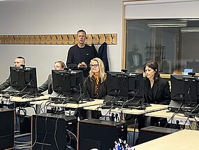people sitting behind computers in a classroom