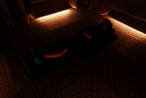 person lying in a low lit room on the floor wearing a VR-headset