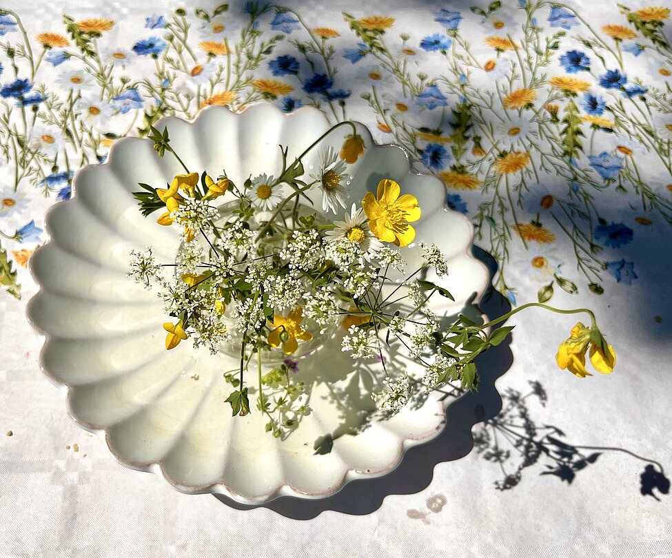 yellow and white flowers on a small white plate