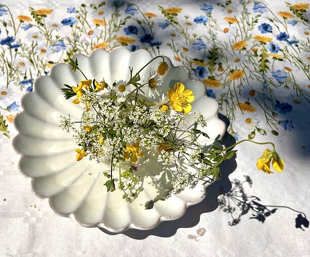 yellow and white flowers on a small white plate